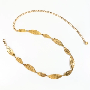 Detail of golden metal waist chain with leaf-shaped plates and hammered texture finish