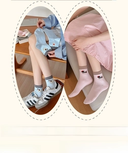 Detail of cotton socks with cartoon dog embroidery in light blue and pink pastel tones