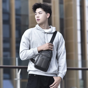 Men's black leather chest bag with textured finish and kangaroo logo on the strap
