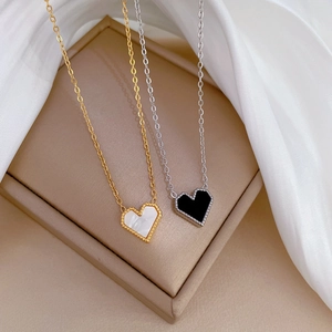 Detail of gold and silver heart necklaces with mother of pearl on beige display