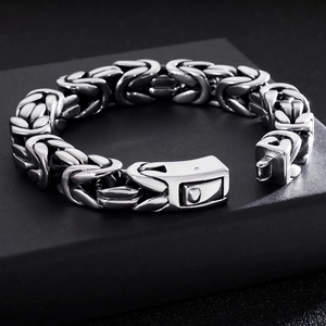 Detailed close-up of chunky silver stainless steel braided chain link bracelet with clasp