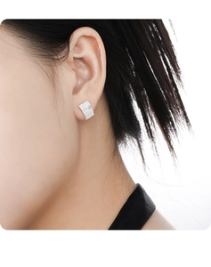 Close-up of S925 sterling silver brushed texture earring with zircon worn by a model