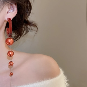 Detail view of oval pearl fringe earrings with vintage acrylic studs on a model