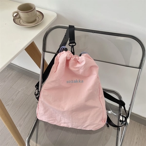 Detailansicht der rosa Nylon-Kordelzugtasche mit gesticktem Logo und Metallbeschlägen