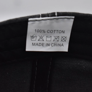 Close-up of the 100% cotton washing label inside a vintage black baseball cap