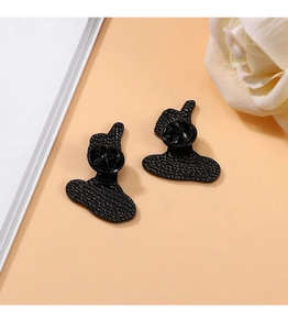 Detail view of two black metal cartoon brooches with butterfly clasps on the back