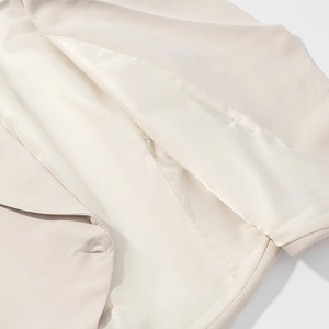Detailed macro view of the lapel and stitching on this beige commute style blazer