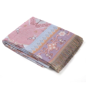 Close-up of geometric jacquard pattern and colorful fringe detail on the woven blanket