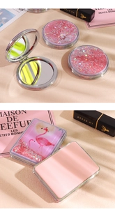 Close-up of portable folding makeup mirror with pink quicksand and flamingo pattern