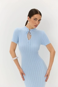Dettaglio dell'abito in maglia azzurro con scollo stringato traforato e texture a coste