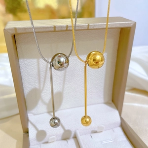 Titanium steel tassel ball necklaces in gold and silver finish on jewelry box