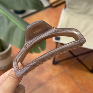 Detailed view of a 10cm amber butterfly hair claw clip with a matte translucent finish
