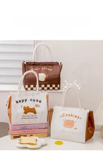 Close-up of waterproof thermal lunch bags with cartoon prints and cotton rope handles