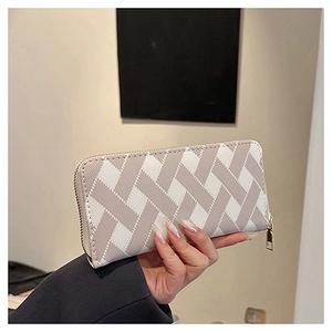 Detail of long zip wallet with cream and grey woven geometric texture and metal zipper