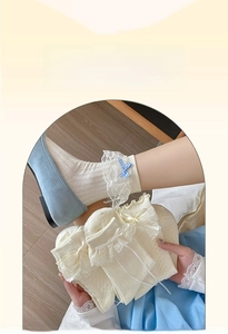 Detail of white Lolita socks with delicate lace edges and blue checkered bow accents