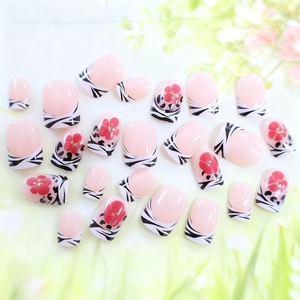 Short square press-on nails with zebra stripes and red floral accents on french tips