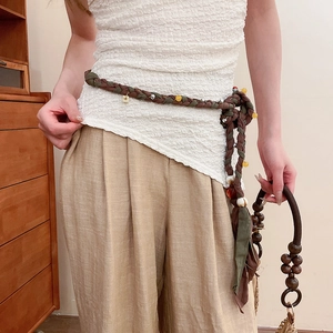 Detail of hand-woven cotton linen waist chain with colorful crystal beads and tassels