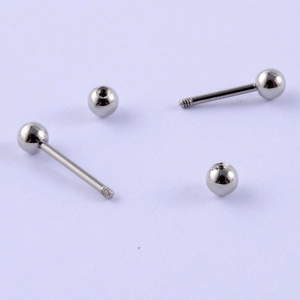Macro shot of polished stainless steel barbell studs with screw-back ball closure