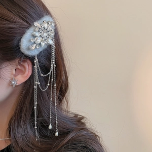 Close-up of rhinestone flower hair clip with chain tassels and matching snowflake earrings