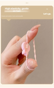 Close-up of a pink high-elasticity hair tie being stretched to show durability