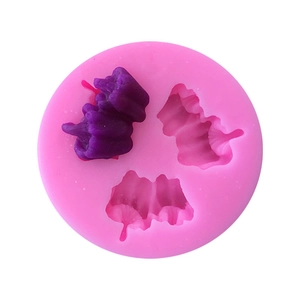 Detail of pink silicone mold with fruit shapes and purple fondant decoration