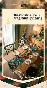Detailed view of dark green Christmas table runner with festive prints and yellow tassels