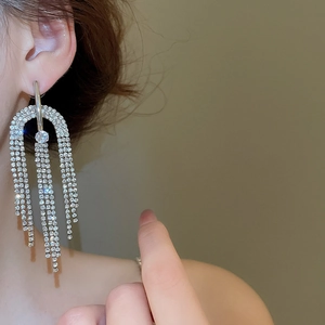 Gros plan de boucles d'oreilles pampilles argentées avec cristaux sur un mannequin