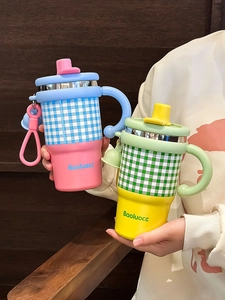 Close-up of checkerboard stainless steel insulated mug with handle and straw lid
