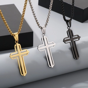 Detailed close-up of hollowed-out cross pendants in gold, silver, and black stainless steel