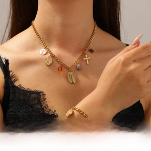 Detail of 18K gold plated bead necklace and bracelet set with religious charms and medals
