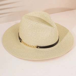 Close-up of beige woven straw hat with black leather strap and gold chain detail