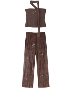 Détail du pantalon large marron foncé avec broderie pailletée d'étoiles argentées