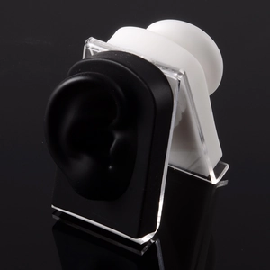 Close-up of black and white silicone ear models on acrylic stands for jewelry display