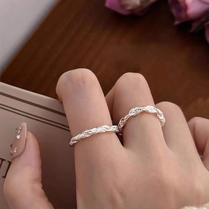 Minimalist silver twisted rope ring set shown on model's fingers with a lifestyle backdrop