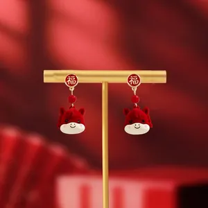 Detailed shot of festive red dragon earrings with gold character on a jewelry stand