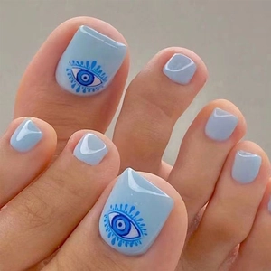 Detail of light blue press-on toenails featuring a unique blue evil eye design