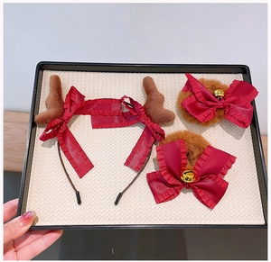 Detail von Weihnachts-Rentier-Haarreif mit roter Schleife und Plüsch-Haarspangen mit Glocken