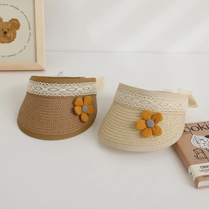 Detail of children's straw sun visor with delicate lace trim and knit flower accents