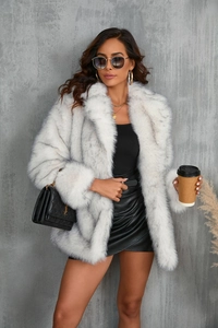 Close-up of white faux fur coat featuring elegant grey tips and a plush luxurious texture