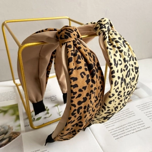 Set of two leopard print knotted headbands in brown and yellow on a gold frame