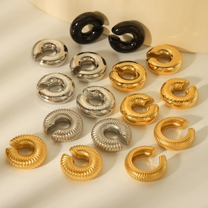 Detailed close-up of geometric textured ear clips in gold, silver, and black finishes