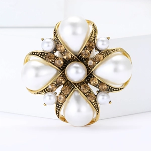 Vintage floral pearl brooch with gold finish and amber rhinestones on white steps