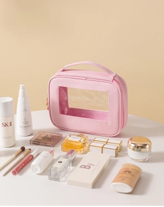Dettaglio della trousse rosa con finestra in PVC trasparente e cerniera dorata