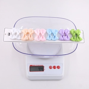 Detailed view of 12 pieces grosgrain ribbon bow hair clips set weighing 44g on a scale