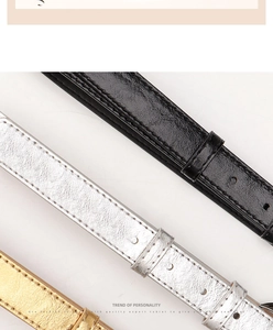 Detail of slim women's faux leather belts in black and silver with sleek needle buckles