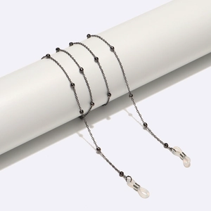 Detail of gunmetal grey minimalist eyewear chain with metal beads on a white display
