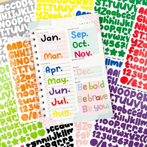 Close-up of weekly planner with colorful alphabet stickers for scrapbook decoration
