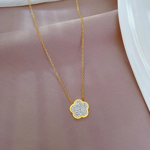 Close-up of gold titanium steel necklace featuring a sparkling crystal-encrusted flower pendant