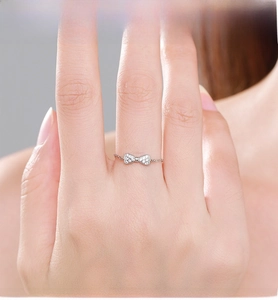 Macro detail of 925 silver bow ring featuring micro-pave stones and chain-style band