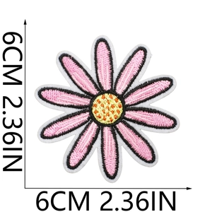 Detail view of a 6cm pink daisy embroidered patch with yellow core and black stitching